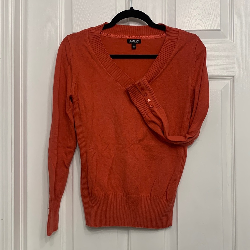 V-neck coral colored sweater with buttons on cuffs